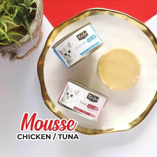 Kit Cat Chicken and Tuna Mousse cans on a decorative plate, showcasing grain-free cat food options for all life stages.
