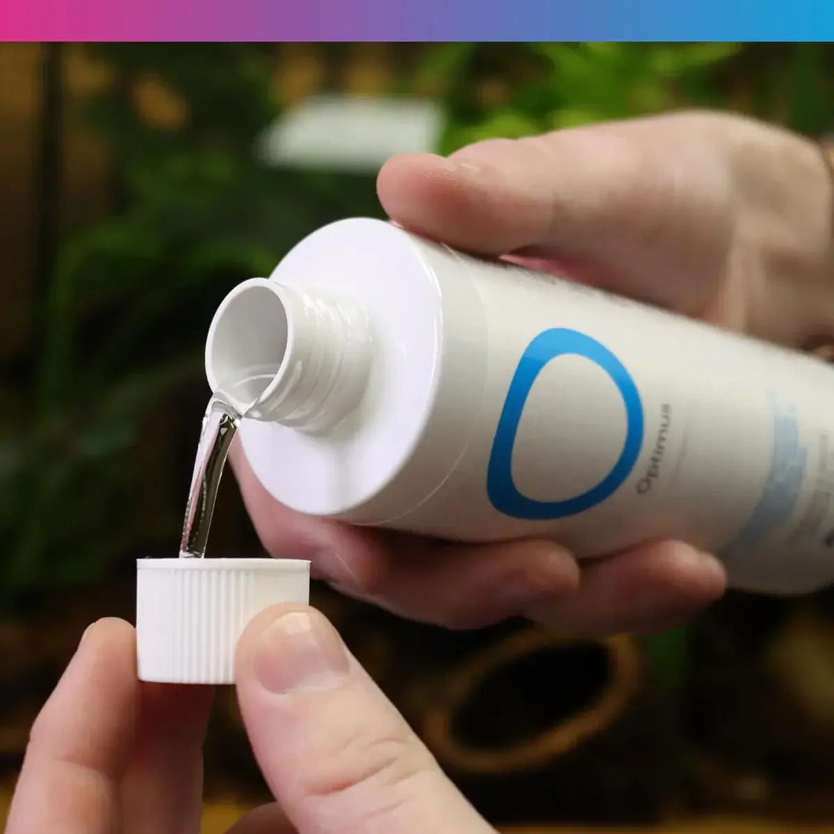 NT Labs Optimus Water Conditioner being poured from bottle, perfect for freshwater and marine aquariums.