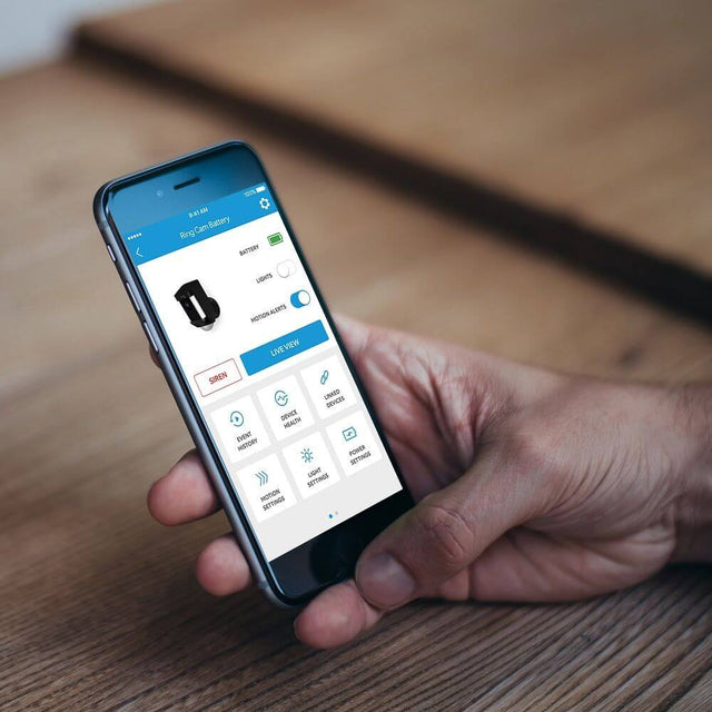 Person using the Ring security app on a smartphone to monitor the battery-operated security camera.