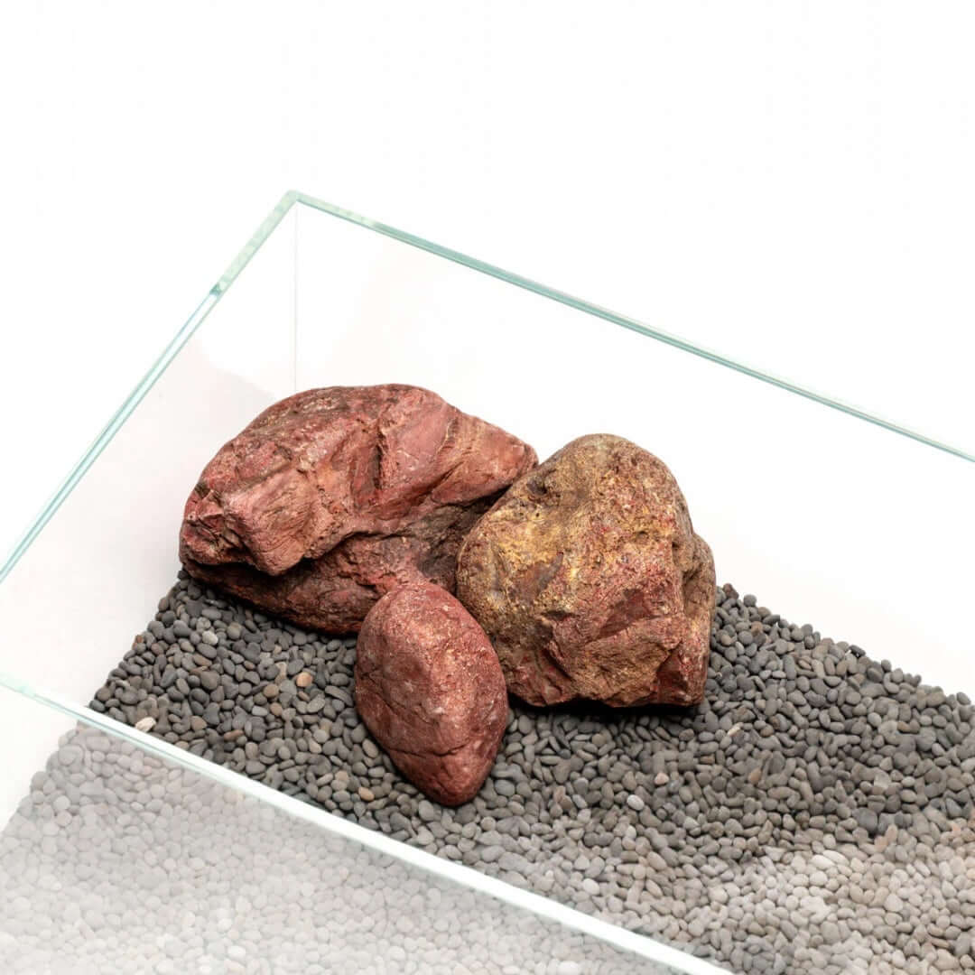 UNS Controsand Kona substrate in aquarium with natural rocks, perfect for aquascaping and safe for aquatic life.