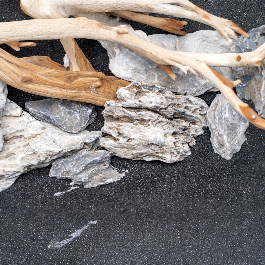Natural driftwood and slate rock pieces for aquascaping with UNS Controsand Maui substrate.