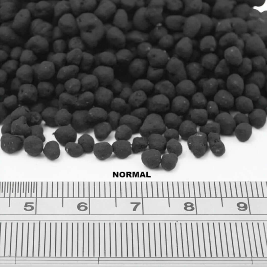 Close-up of UNS Controsoil Black substrate granules, ideal for planted aquariums, showcasing size with a ruler.