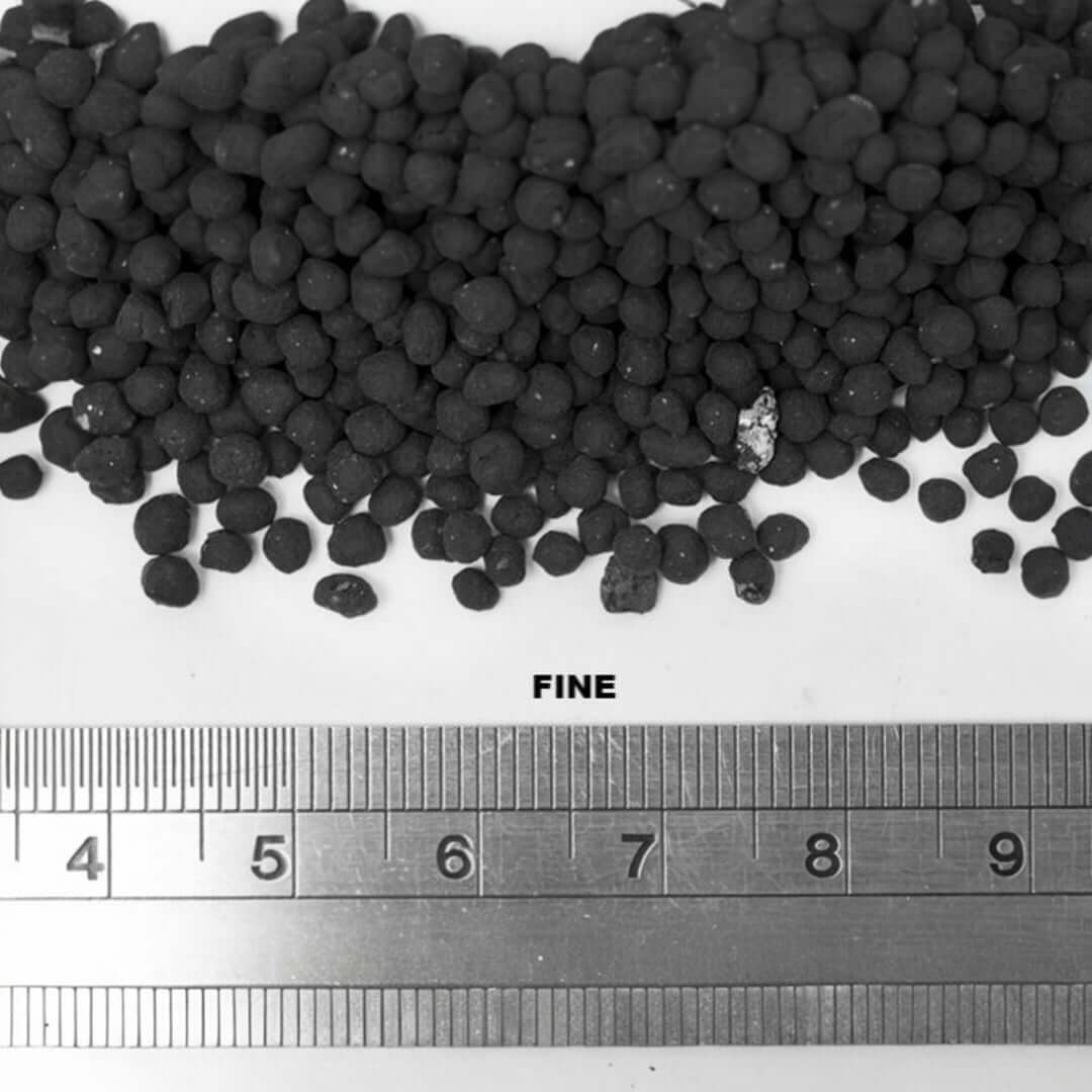 Close-up of UNS Controsoil Black substrate showing fine texture and size comparison with measuring ruler.