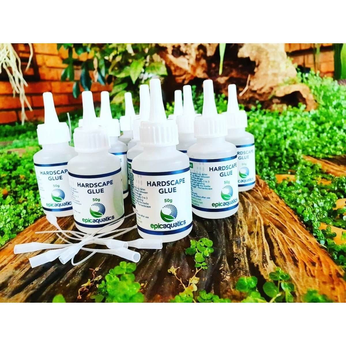 Epic Aquatics Hardscape Glue 50g bottles arranged on a lush green background for aquascaping projects.