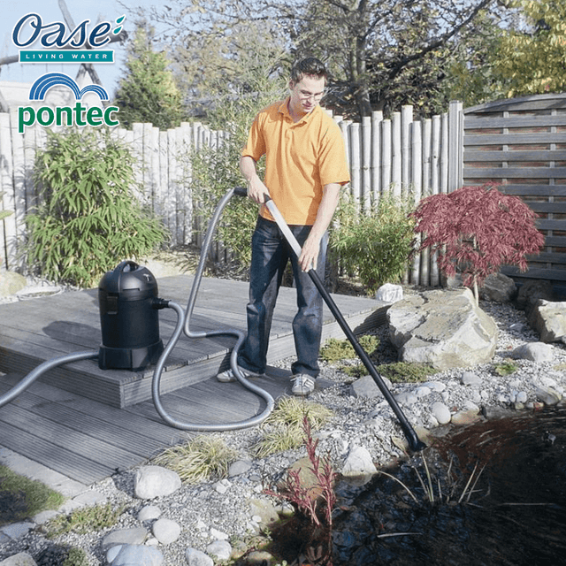 Person using the Pontec Pondomatic Pond and Pool Vacuum Cleaner in a garden setting.