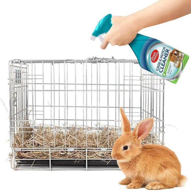 Simple Solution Cage and Hutch Cleaner being used to freshen a rabbit's hutch, featuring a rabbit and clean cage setup.
