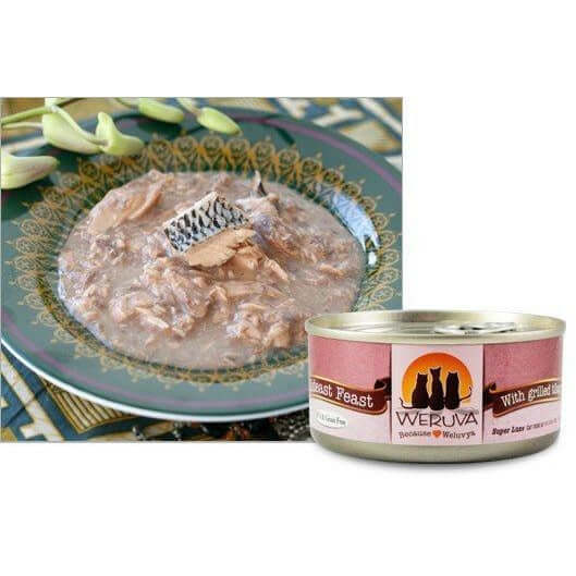 Weruva Mideast Feast Wet Cat Food with tilapia in a bowl and an open can on a decorative surface.