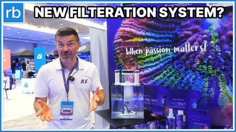 Presentation of a new filtration system at an Aquaforest event, with vibrant coral backdrop and focus on product efficiency.