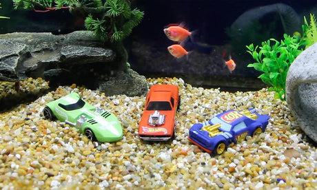 Penn-Plax Hot Wheels Cars Aquarium Decoration Bundle featuring toy cars surrounded by gravel and fish.