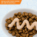 Bowl of dry cat food topped with creamy treat, ideal for meals or pill administration.
