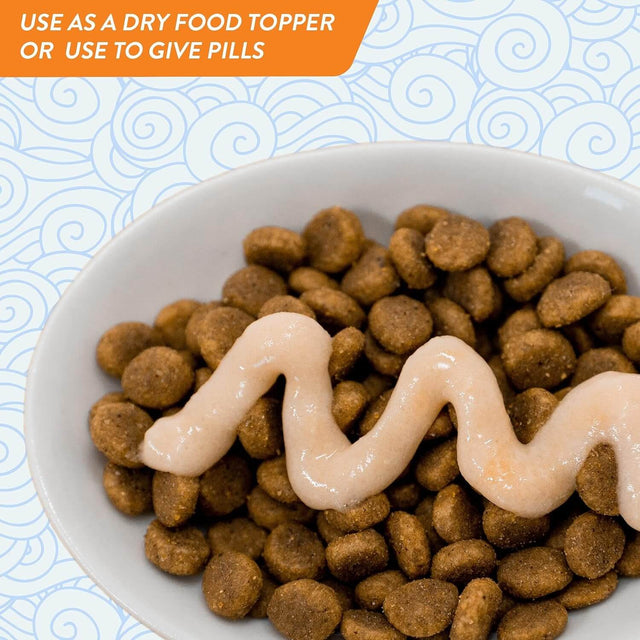 Bowl of dry cat food topped with creamy treat, ideal for meals or pill administration.