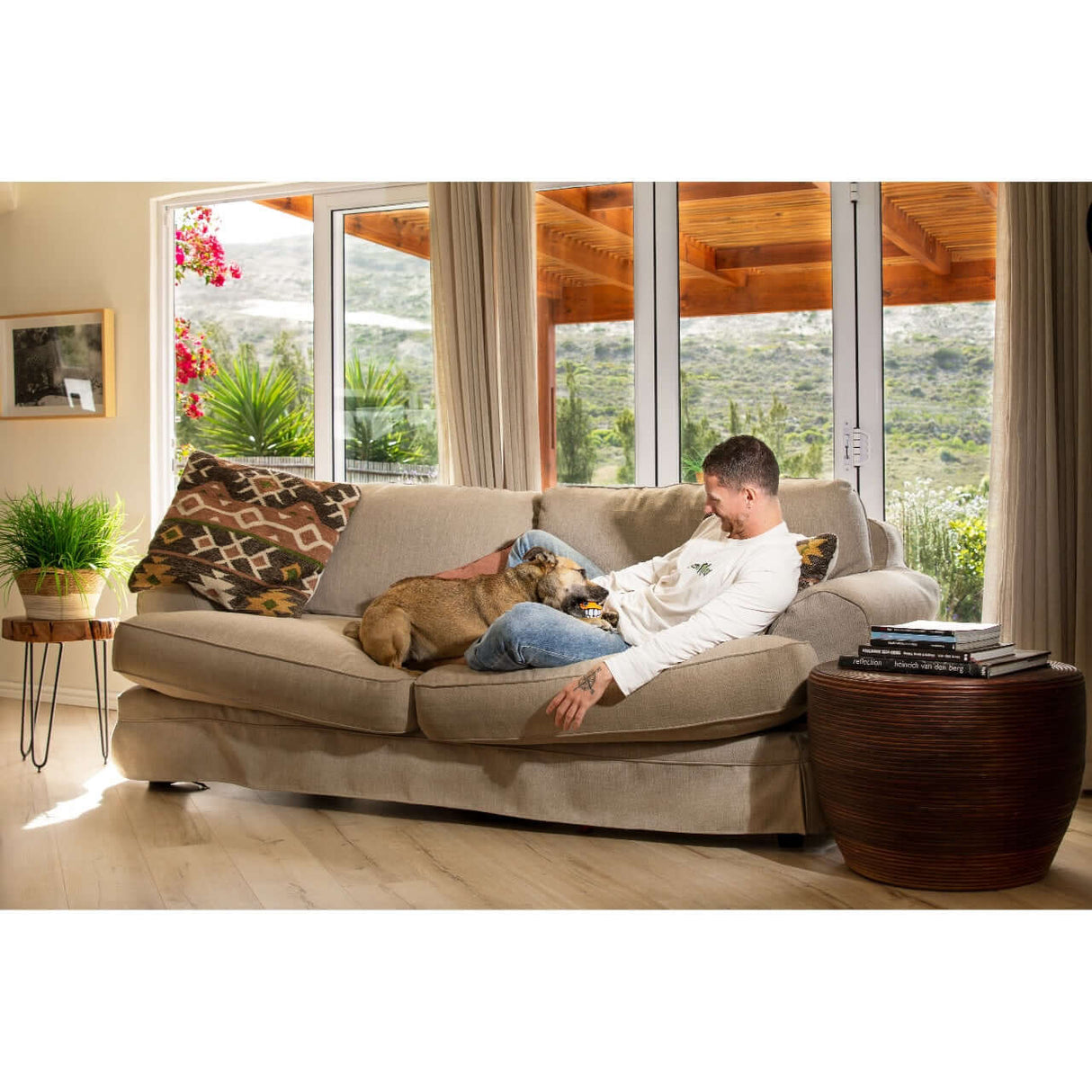 Man relaxing on a sofa with a dog, showcasing comfort and companionship in a cozy living room.