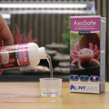 NT Labs AxoSafe 100ml tap water dechlorinator being poured into a measuring cup for axolotl aquariums.