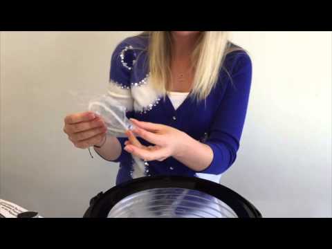 Person demonstrating the setup of a Bio Bubble Aquarium at a table, showcasing the product's components.