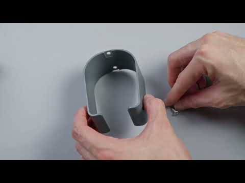 Person assembling a gray plastic component with hands, detailing attachment process.