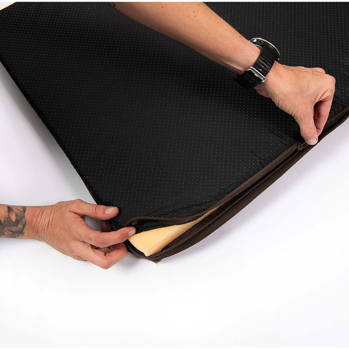 Rogz Outdoor Flat Dog Bed showing hands adjusting the cover, emphasizing comfort and durability for outdoor use.
