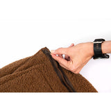 Close-up of a hand unzipping the soft, brown material of a cozy dog bed.