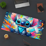 Stitch Mouse Pad 80x40cm with colorful paint splatters and a vibrant blue Stitch graphic on a modern desk.