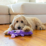 A dog playing with the Stuffing-Free Big Squeak Moose plush toy on a wooden floor.