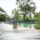 Tetra Pond Flakes 1L can by a tranquil pond, promoting healthy growth in pond fish with a balanced diet.