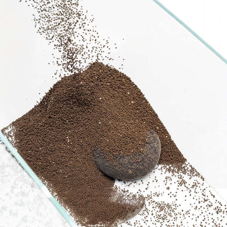 UNS Controbase nutrient-rich substrate for planted aquariums, showing granules and a mesh scoop.