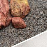 Close-up of UNS Controsand Kona substrate with smooth rocks, ideal for aquascapes in freshwater tanks.