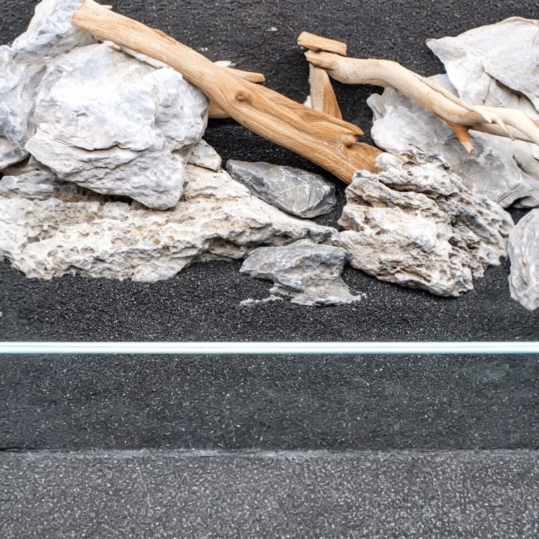 Natural substrate and driftwood arrangement for freshwater aquariums featuring UNS Controsand Maui.