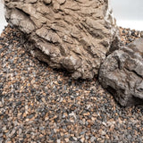 Natural substrate for aquariums featuring varied tones and granule sizes, with rock formations for ideal aquascaping.