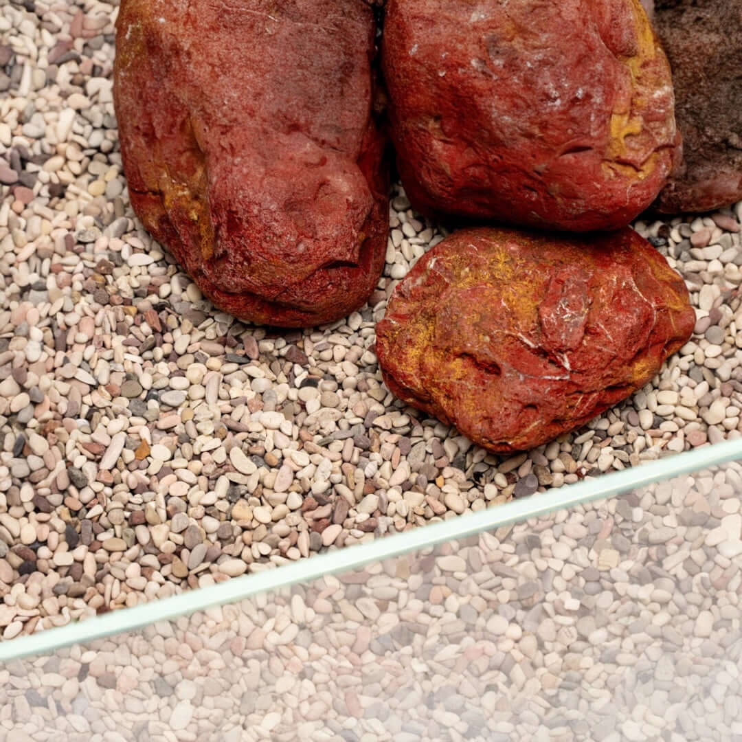 Close-up of UNS Controsand Tahoe substrate with natural rocks, ideal for freshwater aquariums and terrariums.