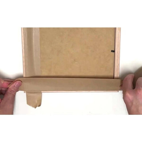 Applying GoGreen water-activated gum tape to a cardboard box for secure sealing and protection.