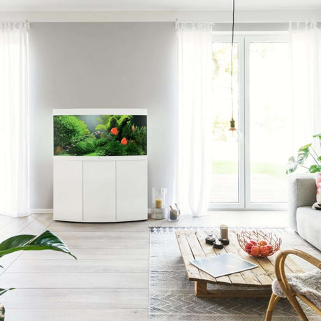 Juwel Vision Aquarium and cabinet displayed in a stylish living room setting with lush greenery and fish.