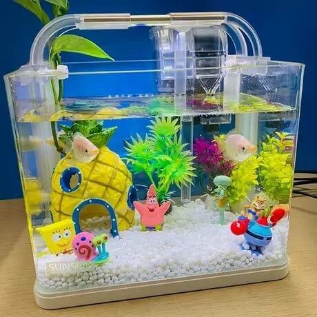 SpongeBob SquarePants aquarium with pineapple house, characters, and colorful plants in a clear fish tank.