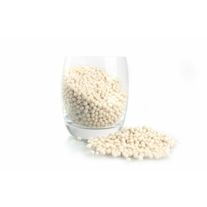 Sure Pure NP Beans Bio Pellets in a glass, promoting SPS Hard Coral growth and vitality for marine aquariums.